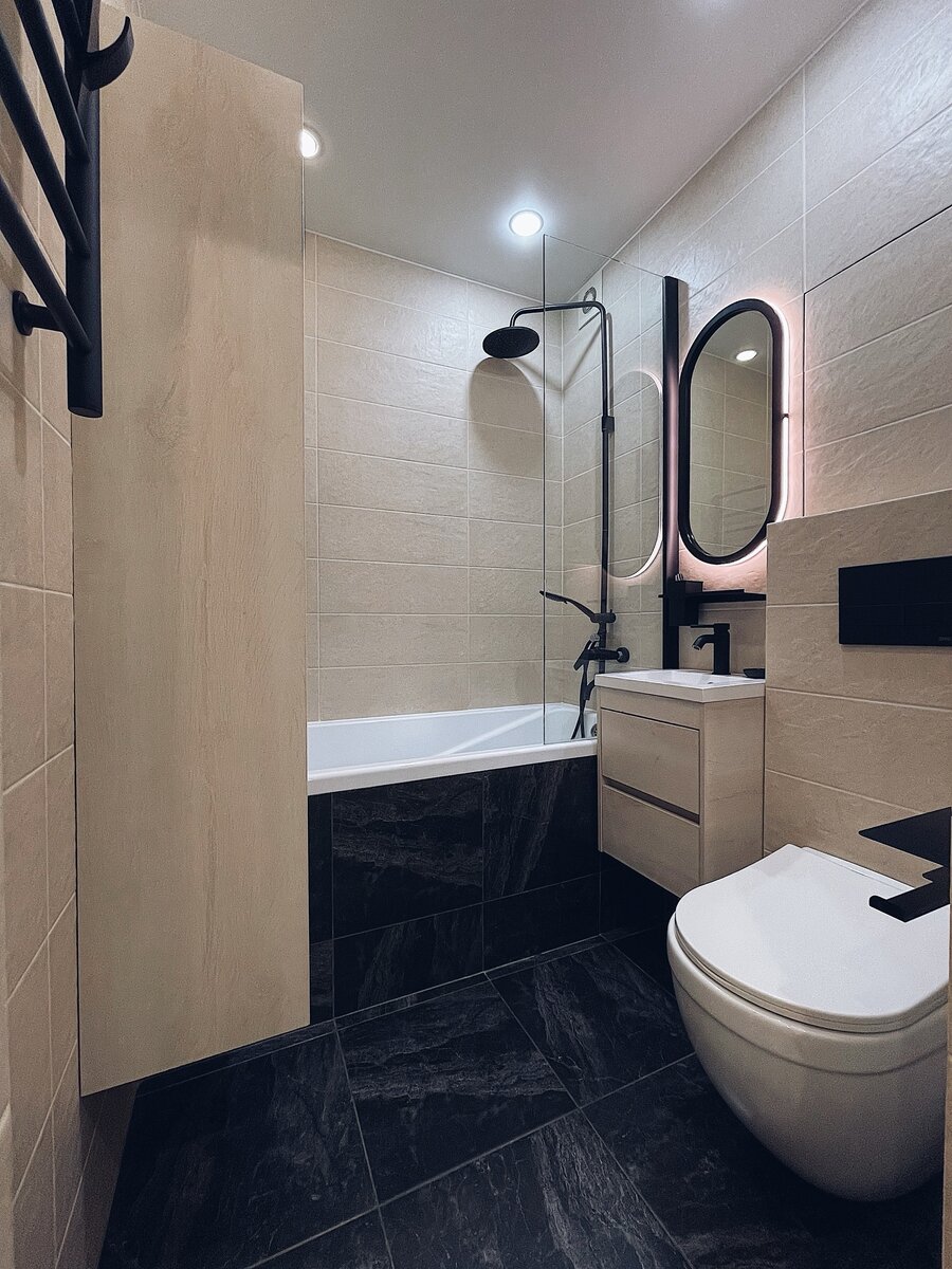 Интерьер ванной комнаты построен на контрасте темного и бежевого. Интересно, что экран ванной тоже отделали плиткой. Не скажу, что мне нравится, но выглядит как минимум необычно